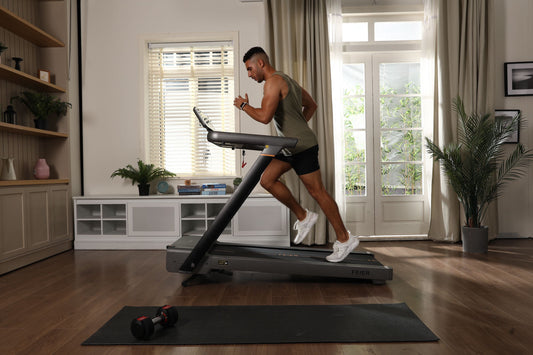 A man is runnning on an incline treadmill at home